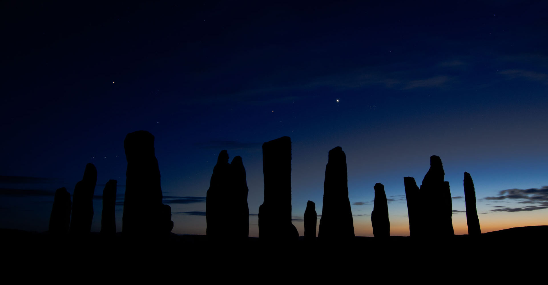 A silhouette of the Callanish Stones in Scotland at dusk